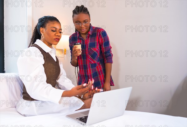Young businesswomen of black ethnicity. Teleworking with a laptop from a hotel room