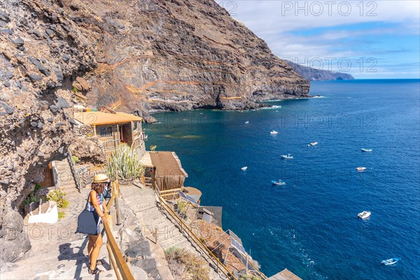 A young tourist in summer from the viewpoint looking and enjoying the cove of Puerto de Puntagorda