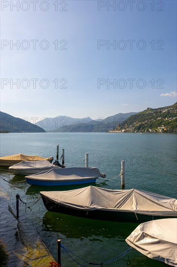 Port with Boats in Brusino Arsizio on the Waterfront in a Sunny Summer Day on Lake Lugano and Mountain View over Morcote