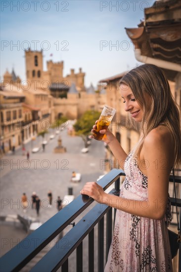 Young blonde caucasian woman in a long pink dress enjoying a beautiful rural hotel in the town of Olite in Navarra. Spain
