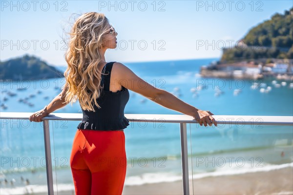 Blonde woman on a terrace enjoying summer vacations