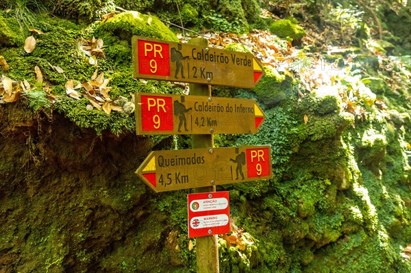 Signs on the trekking trail next to the waterfall in Levada do Caldeirao Verde