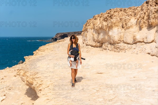 A young mother with her son walking on the path in the Cuevas de Ajuy