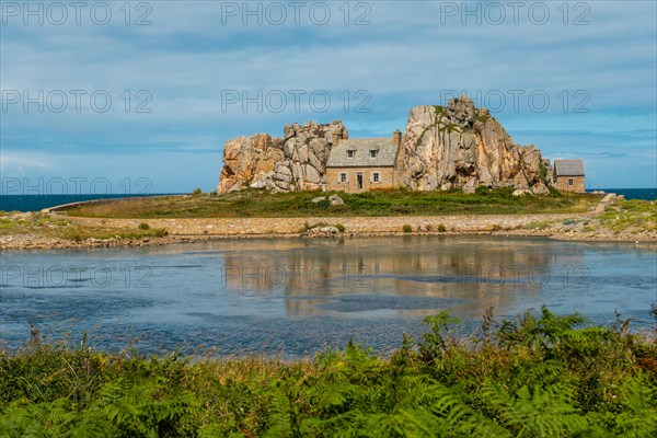 House between rocks next to a beautiful lake