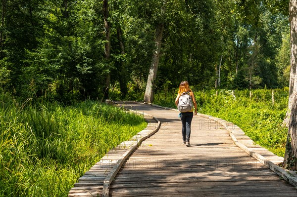 A young woman on the footpath along a footbridge between La Garette and Coulon