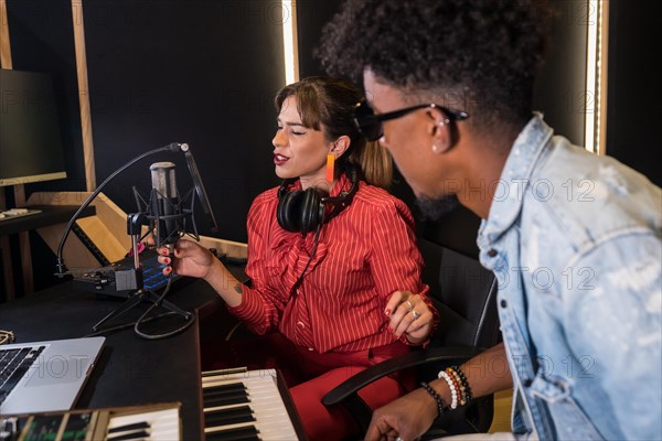 Female caucasian singer and black pianist recording a new album in studio