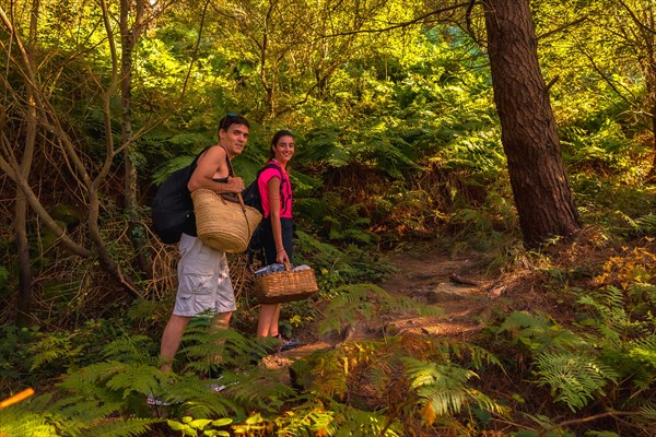 A young Caucasian couple walking along the mountain path towards a romantic summer picnic