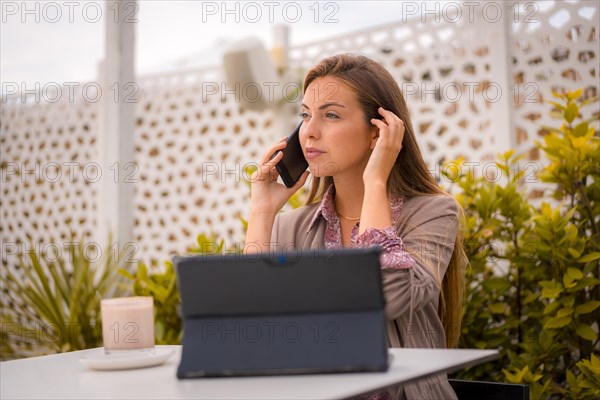 Portrait of a female executive and businesswoman having breakfast in a restaurant talking on the phone