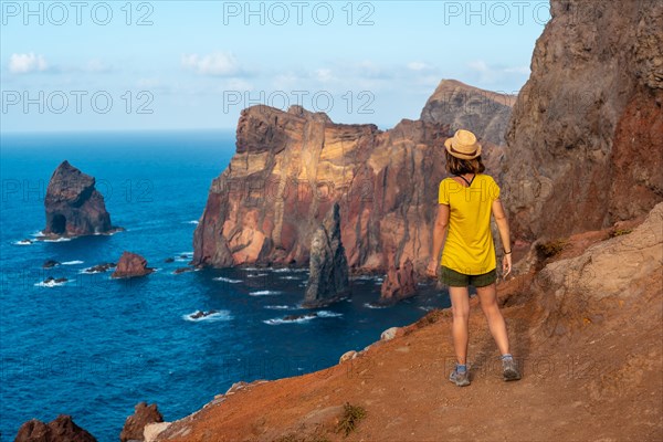 A young woman in Ponta de Sao Lourenco in summer looking at the landscape and rock formations