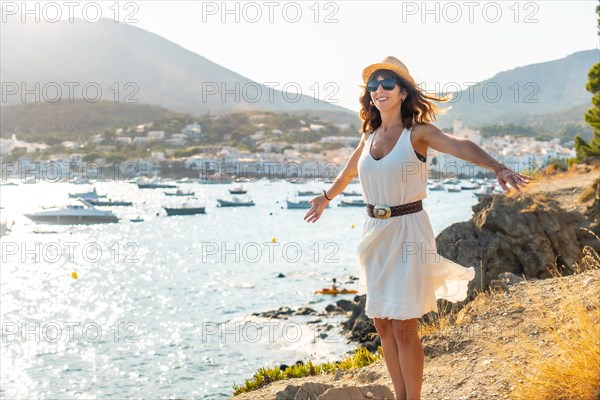 A young woman in a white dress and hat in Cadaques enjoying the summer