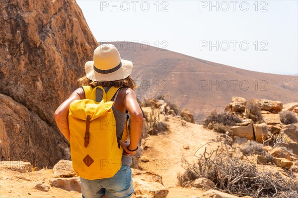 A girl hiker with a yellow backpack on the Mirador de la Penitas trail in the Penitas canyon