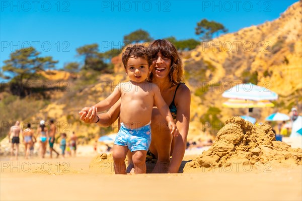 Mother and son playing on the beach at Praia do Barranco das Belharucas