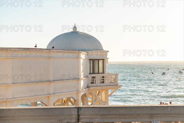 Moorish white building on the beach of La Caleta in the city of Cadiz at sunset. Andalusia