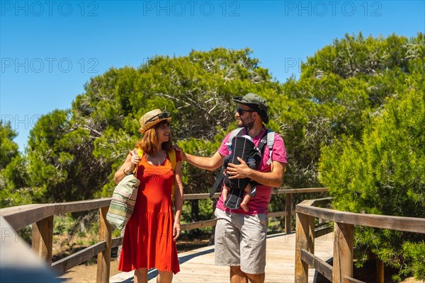 Some young parents on the path to Playa Moncayo in Guardamar del Segura next to Torrevieja