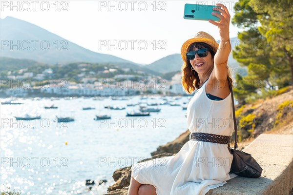 A young woman on vacation taking a selfie in Cadaques by the sea