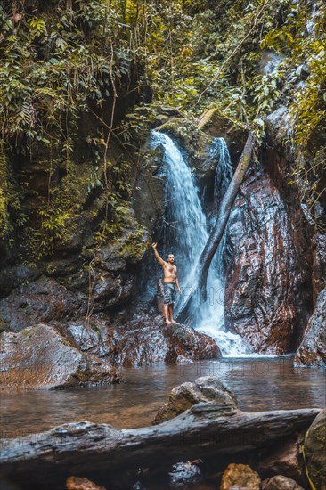 A young man in a waterfall of the Cerro Azul Meambar National Park