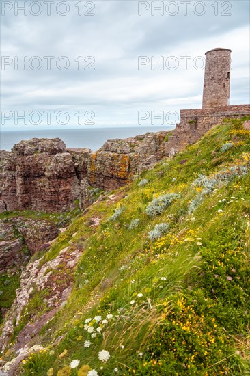 The beautiful coastline next to the Phare Du Cap Frehel is a maritime lighthouse in Cotes-dÂ´Armor France . At the tip of Cap Frehel