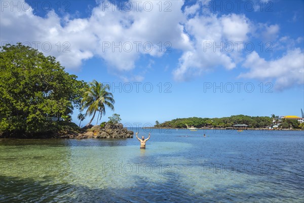 A young man entering the Caribbean Sea at West End Beach on Roatan Island. Honduras