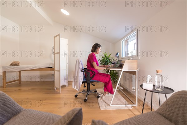 Wide view of a studio office with a nutritionist doctor working from home