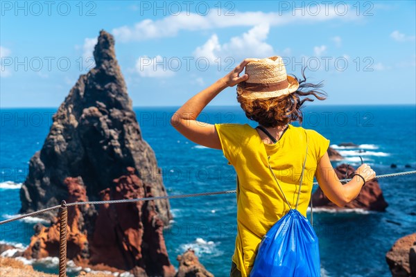 A young woman in the viewpoint looking at the rock formations at Ponta de Sao Lourenco