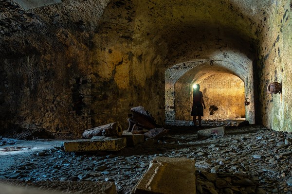 A young man in the bunker in the basement at the Fort des Capucins a rocky islet located in the Atlantic Ocean at the foot of the cliff in the town of Roscanvel on the Crozon peninsula in France