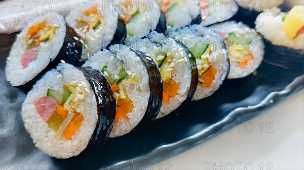 Close up of a Kimbap served in a black long plate