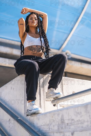 Young black woman with long braids and tattoos