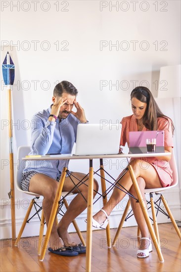 A couple teleworking at home