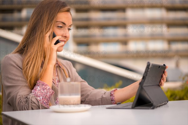 Commercial blonde woman having a decaffeinated coffee for breakfast on a work call