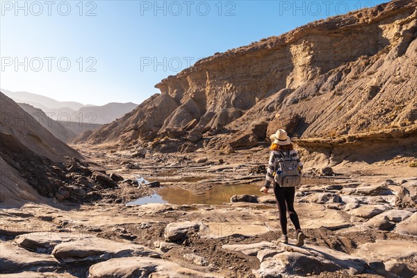 A young woman on a trek in the Travertino waterfall and Rambla de Otero in the Tabernas desert one spring afternoon