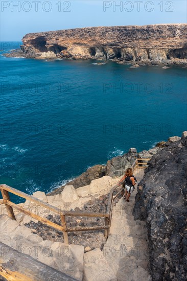 A young woman on the stairs of the path towards the caves of Ajuy