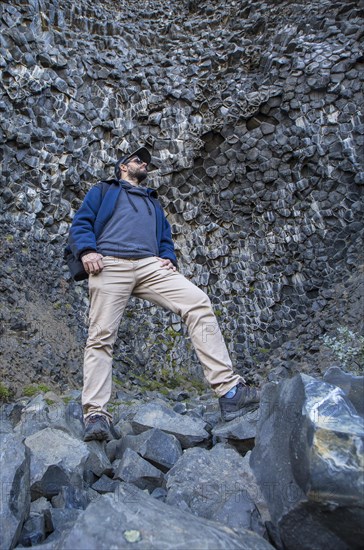 A boy in a fantastic stone shapes on the Jokulsargljufur trekking trail