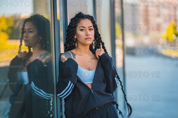 Urban session. Young woman of black ethnicity with long braids and with tattoos