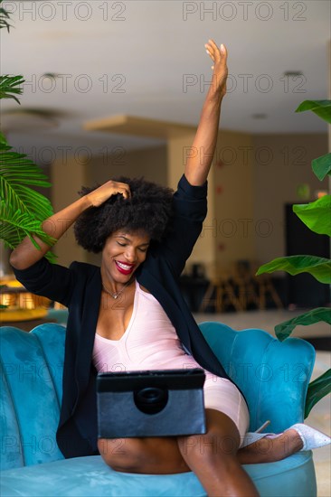 Young entrepreneur of black race and afro hair making a video call very happy