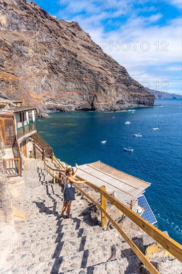 A young tourist descending the stairs to reach the cove of Puerto de Puntagorda