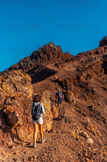 A young woman looking at the crater of the Teneguia volcano on the route of the volcanoes