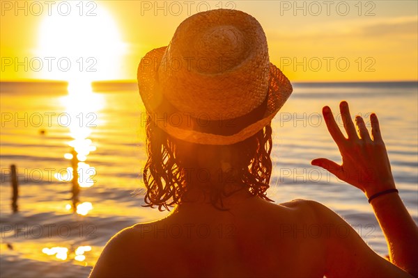 A young girl with a hat on a sunset in Roatan. Honduras