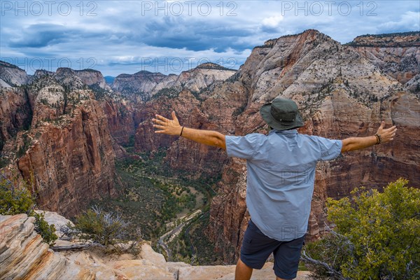 A man celebrating the trekking of Angels Landing Trail in Zion National Park