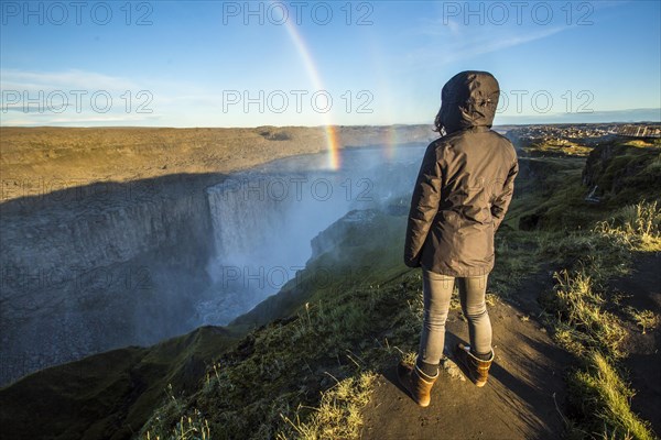 A young woman looking at the Dettifoss Waterfall