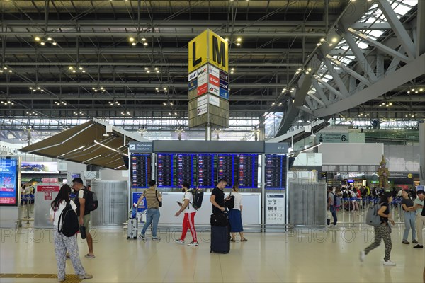 People in front of departure board