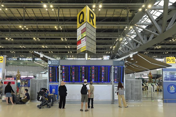 People in front of departure board