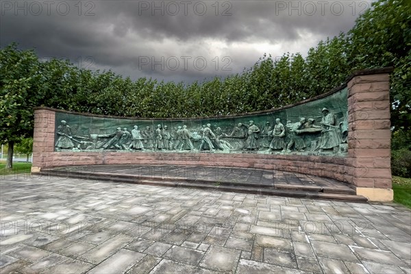 Dark clouds over crucible casting monument Monument for production of steel crucible steel in the form of panorama semicircle by sculptor Artur Hoffmann from 1952 for steel workers of Krupp Stahlwerke depicting half relief of crucible steel production