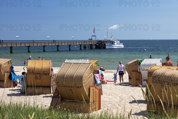 Pier and sunbathers in beach chairs at the seaside resort Haffkrug