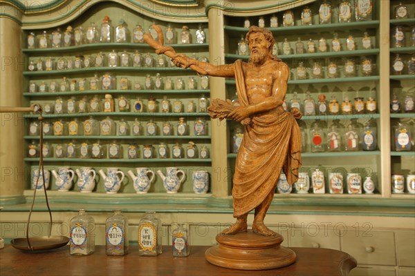 Interior view with sculpture and rows of bottles sorted in the shelf