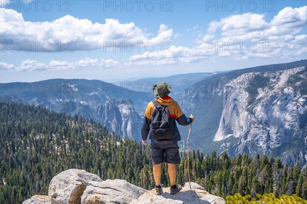 A young man with a stick for walking in Sentinel Dome in Yosemite National Park. United States