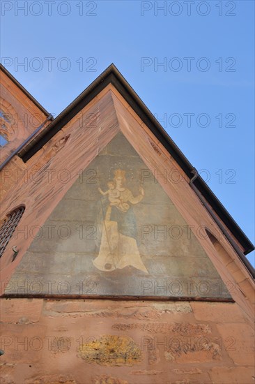 Historic mural with Madonna figure and halo with baby Jesus at the corner of Heiliggeistkirche