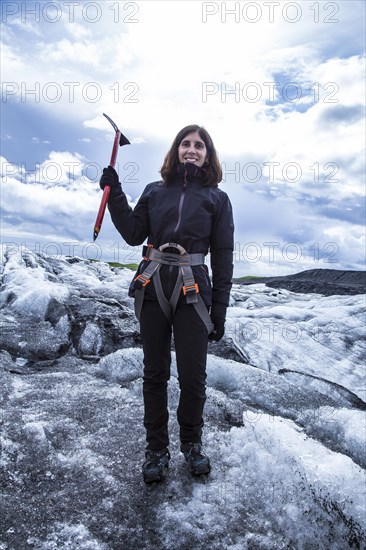 A young woman on her back with booties and hammer on the trekking of the Svinafellsjokull glacier. Iceland