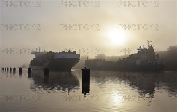 Container ship sailing in fog in Kiel Canal