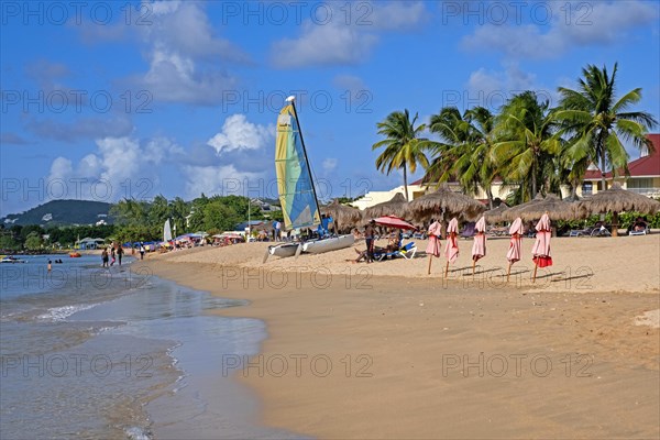 Tourists sunning on sandy beach of Rodney Bay