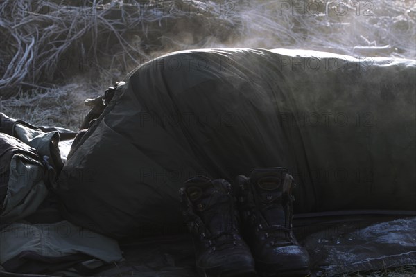 A sleeping bag steams in the morning sun after a frosty night